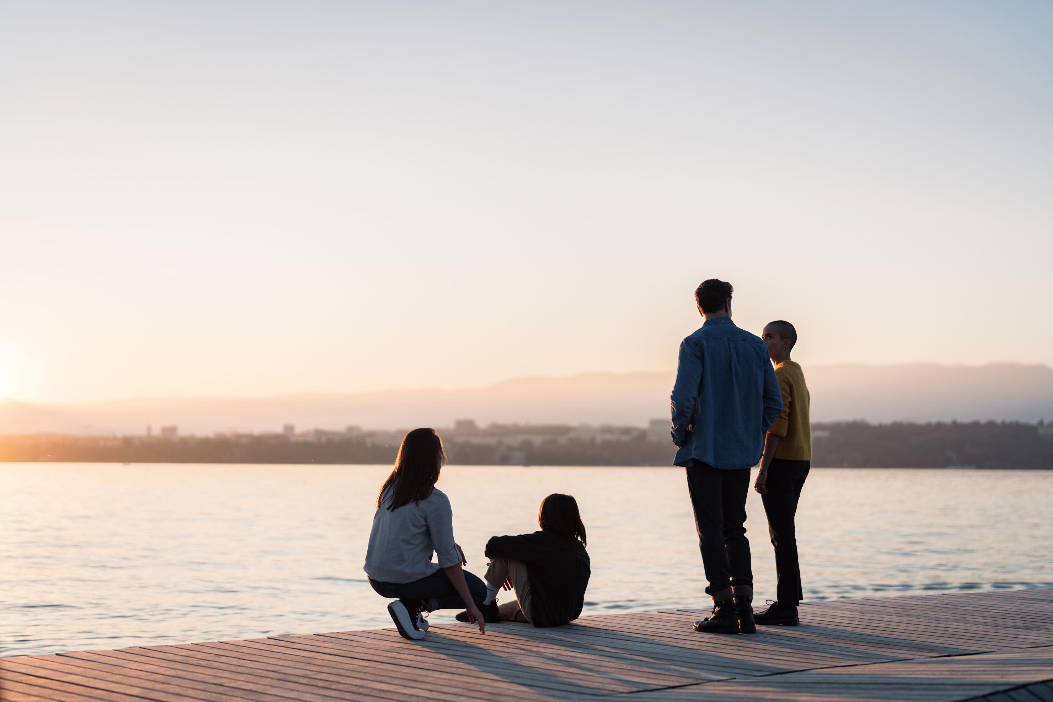 Groupe de personnes de dos sur le quai qui regardent le lac