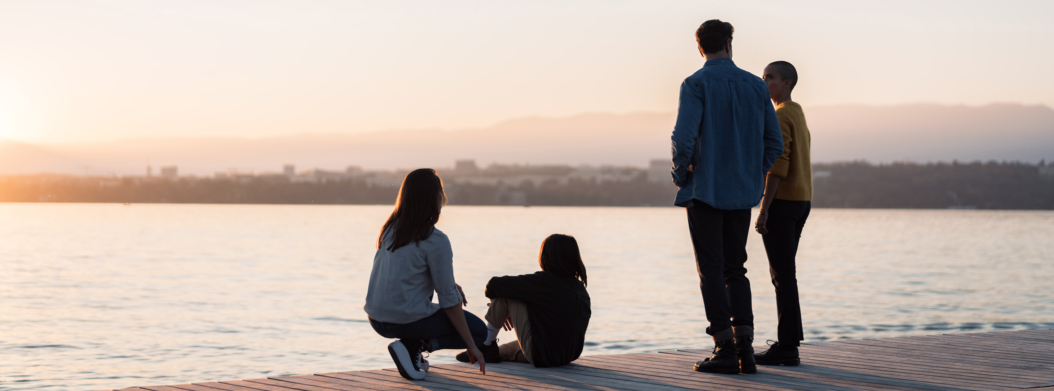Groupe de personnes de dos sur le quai qui regardent le lac