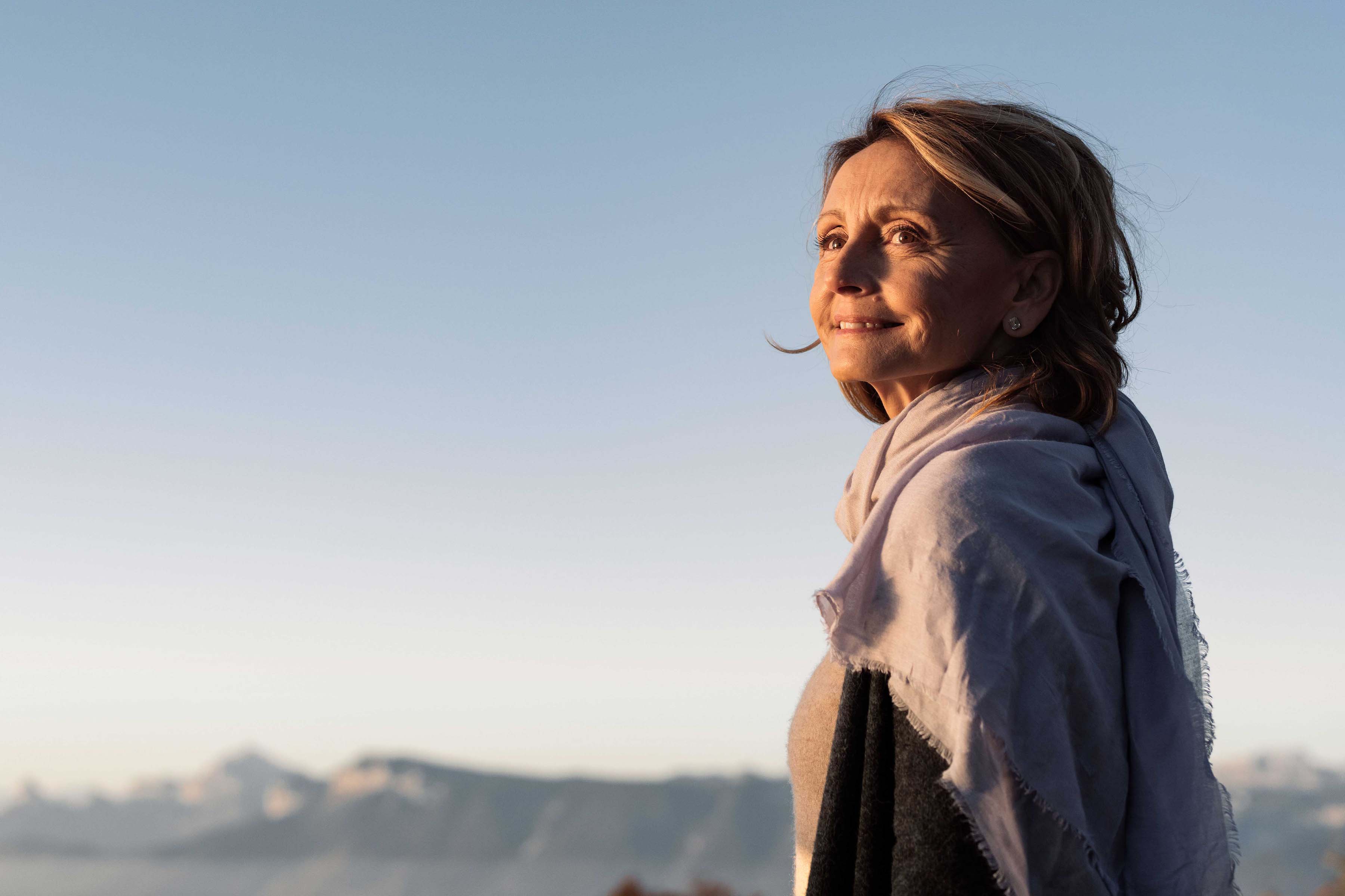 Femme avec un foulard au tour du cou illuminée par le soleil