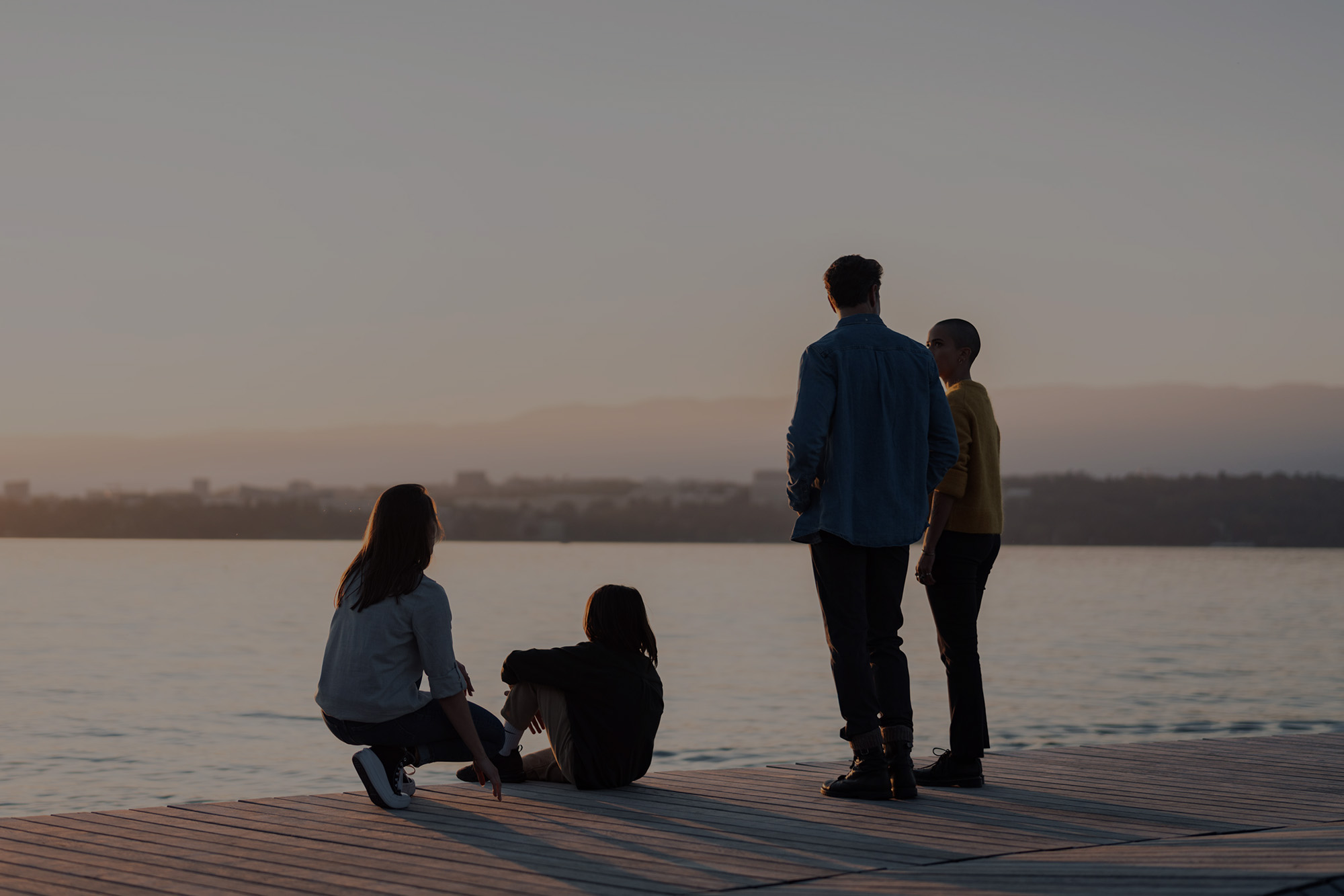 Groupe de personnes de dos sur le quai qui regardent le lac