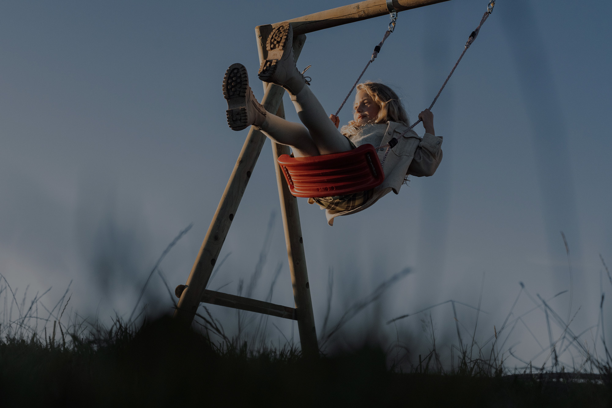 Petite fille blonde sur une balançoire