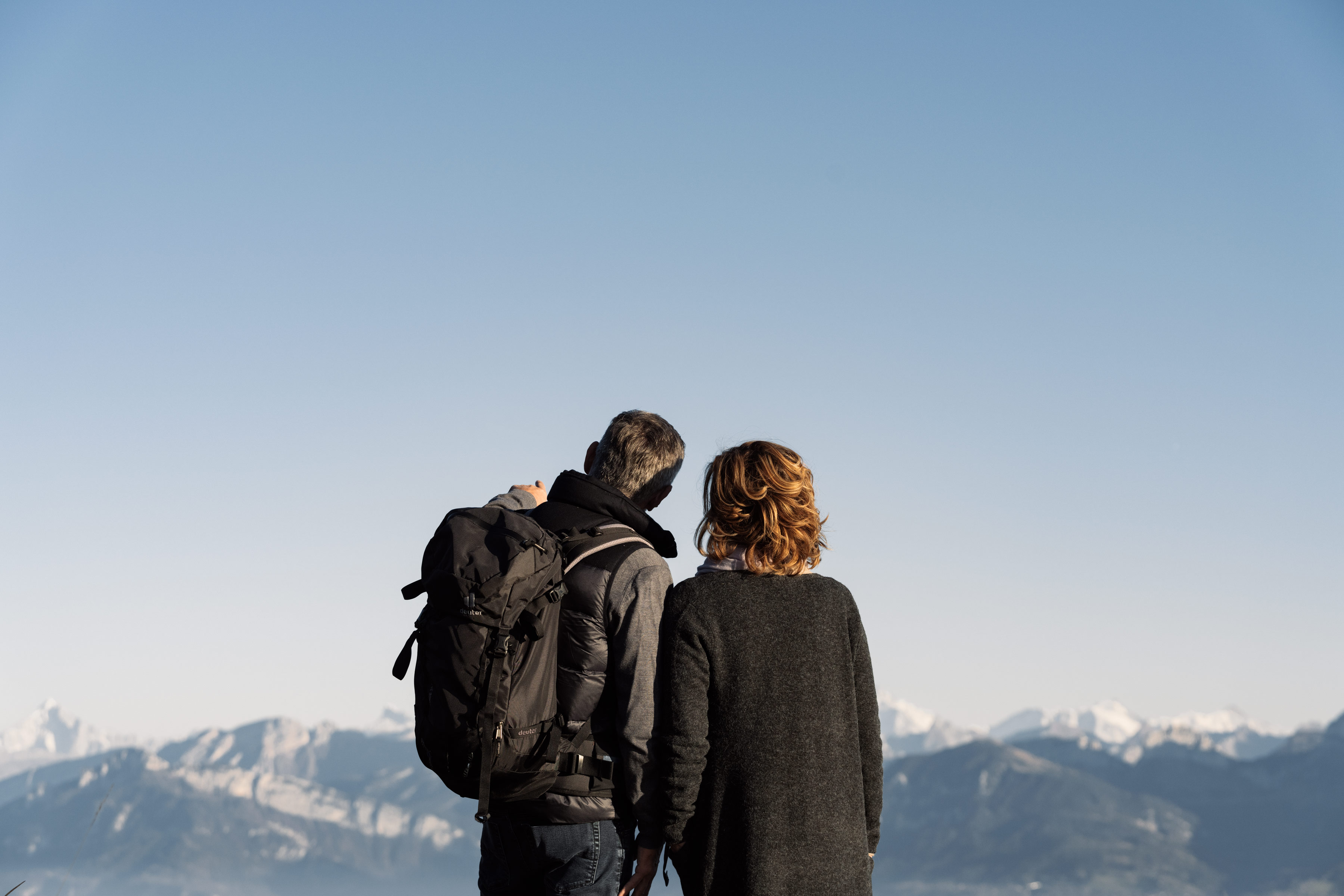 Couple en rando face aux montagnes