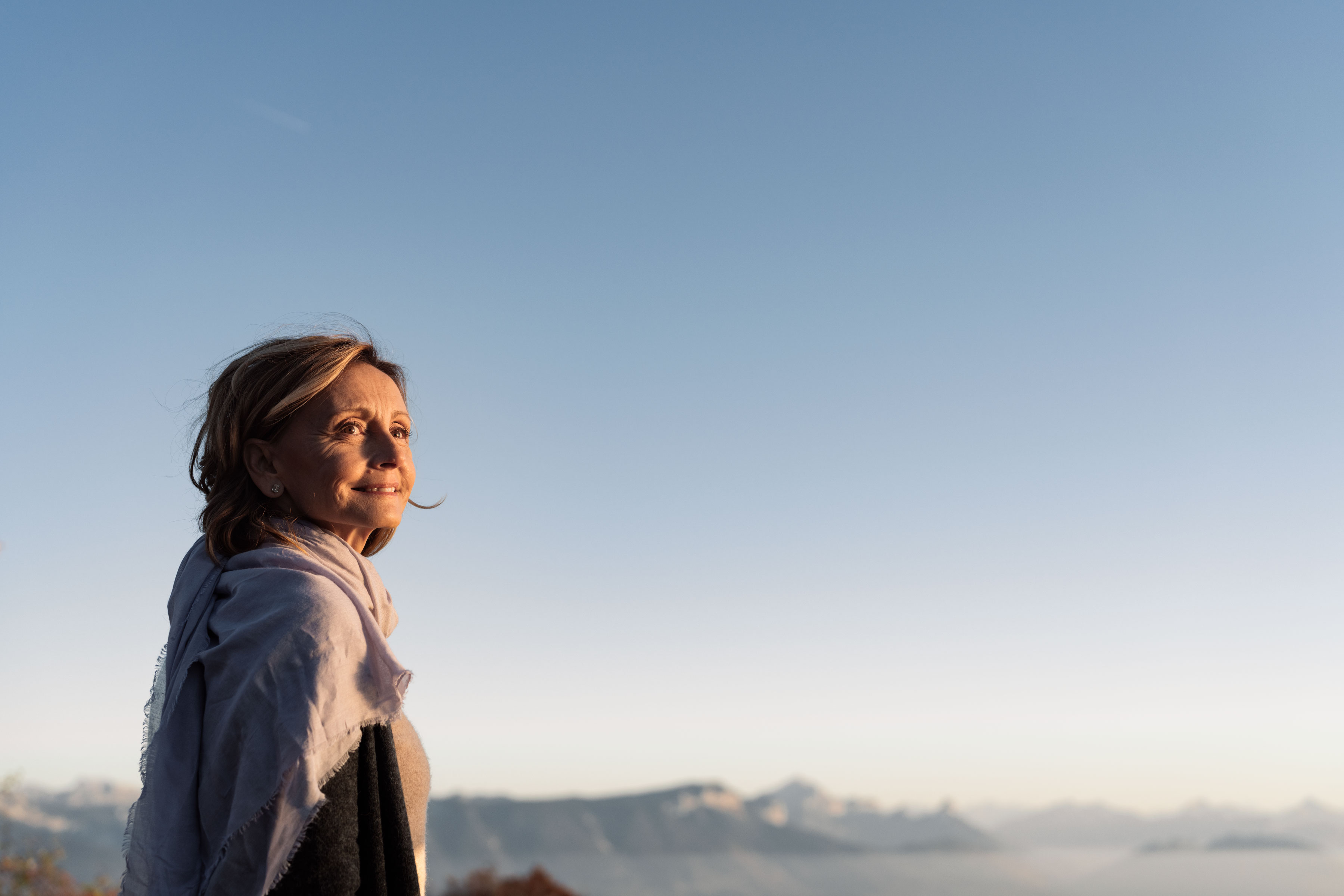 Femme avec un foulard autour du cou illuminée par le soleil